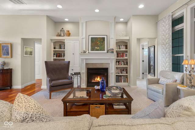 living room with built in shelves and a tile fireplace