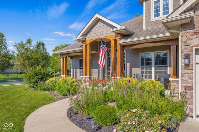 entrance to property featuring covered porch and a lawn