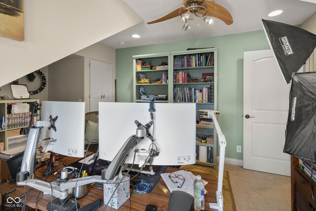 carpeted office space featuring ceiling fan