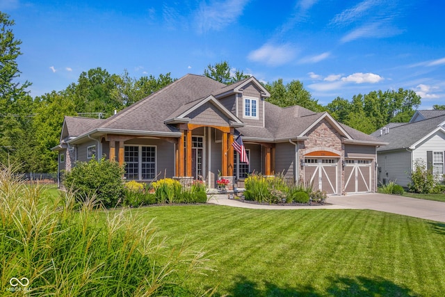 view of front of property featuring a garage, covered porch, and a front lawn