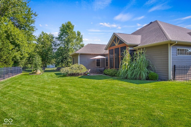 back of house with a sunroom and a lawn