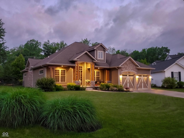 craftsman inspired home featuring a garage and a lawn