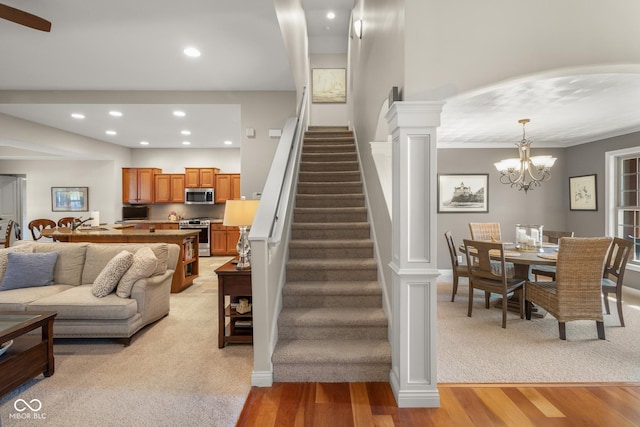 living room featuring decorative columns, light hardwood / wood-style flooring, and an inviting chandelier