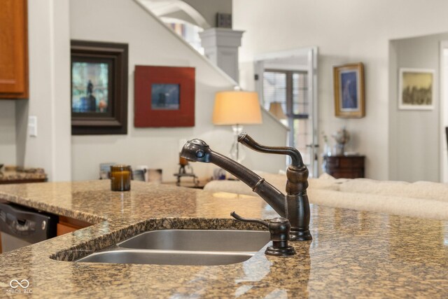 kitchen with sink, dark stone counters, and dishwasher