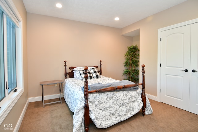 bedroom with light carpet and a closet