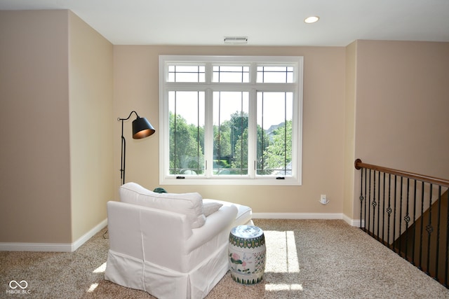 living area featuring light carpet and a wealth of natural light