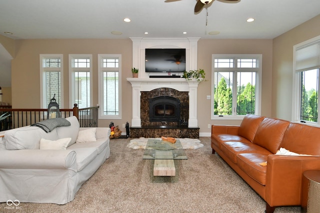 carpeted living area with recessed lighting, baseboards, ceiling fan, and a high end fireplace