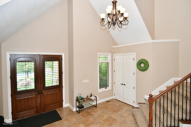 entrance foyer with high vaulted ceiling, light tile patterned floors, and an inviting chandelier