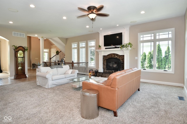 living room with a high end fireplace, a healthy amount of sunlight, visible vents, and recessed lighting