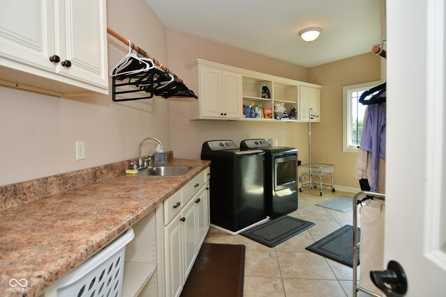 laundry room featuring washing machine and clothes dryer, sink, cabinets, and light tile patterned floors