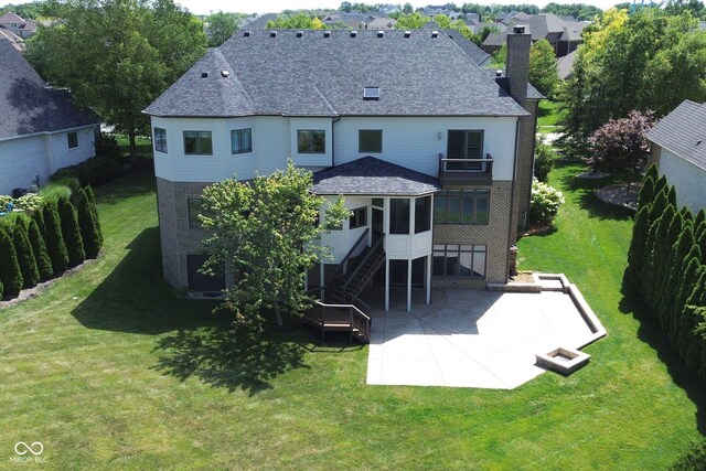 rear view of house featuring a patio area, a sunroom, and a yard