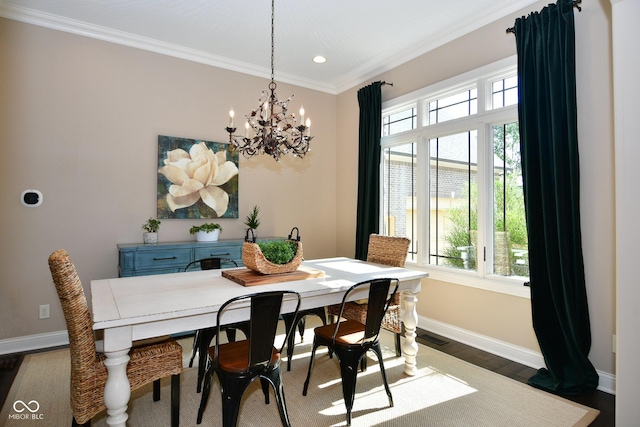 dining space with baseboards, a notable chandelier, wood finished floors, and crown molding