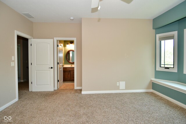 unfurnished bedroom featuring light carpet, ensuite bath, and ceiling fan