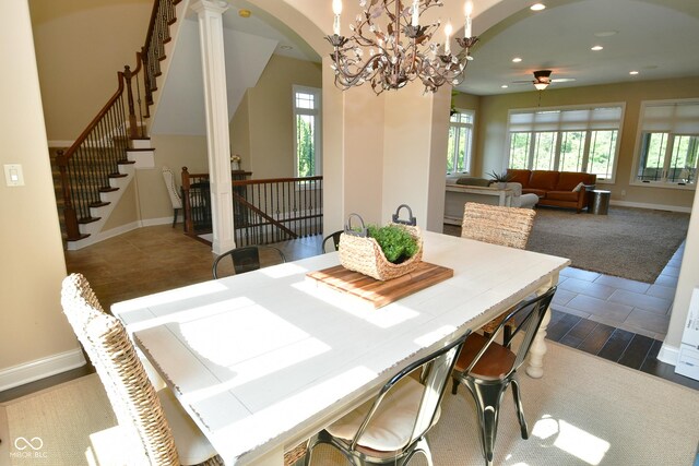 dining room featuring decorative columns, tile patterned floors, and ceiling fan with notable chandelier