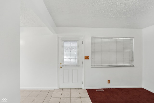 tiled foyer entrance featuring a textured ceiling