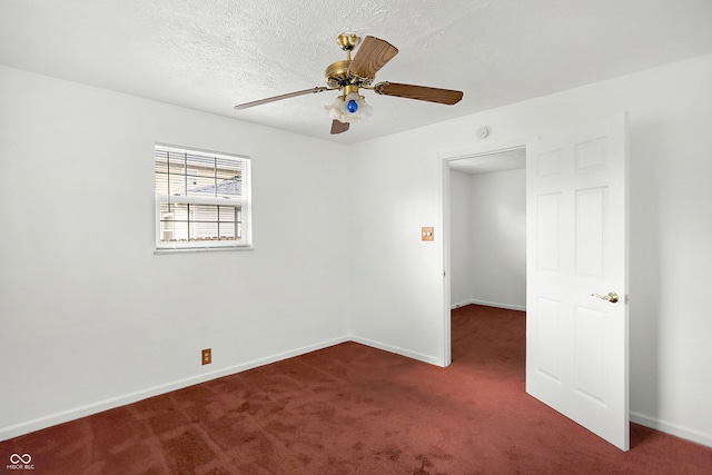 empty room featuring ceiling fan and dark carpet