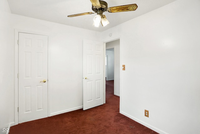 unfurnished bedroom featuring dark colored carpet and ceiling fan