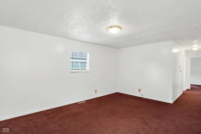 carpeted spare room with a textured ceiling