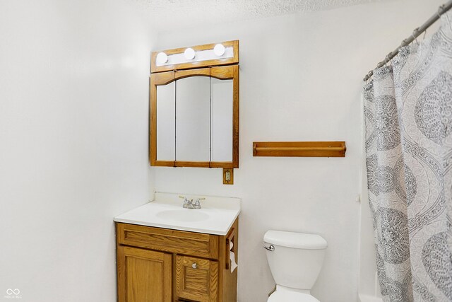 bathroom with toilet, vanity, and a textured ceiling