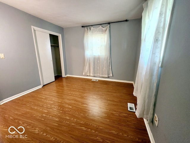 unfurnished bedroom featuring wood-type flooring and a closet