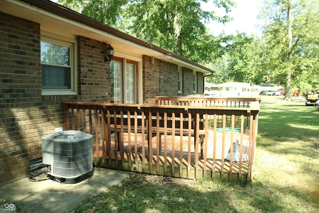 wooden deck with a yard and central AC unit