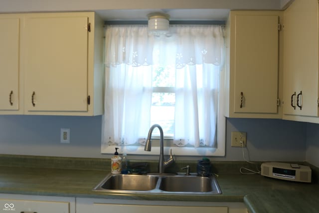 kitchen featuring sink and white cabinetry