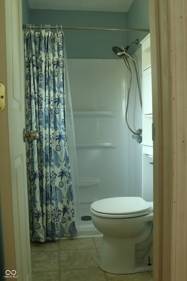 bathroom with toilet, tile patterned floors, and a shower with shower curtain