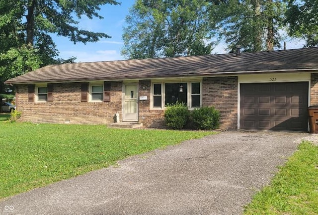 single story home featuring driveway, roof with shingles, a front yard, an attached garage, and brick siding