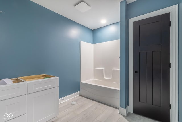 bathroom with bathing tub / shower combination and wood-type flooring