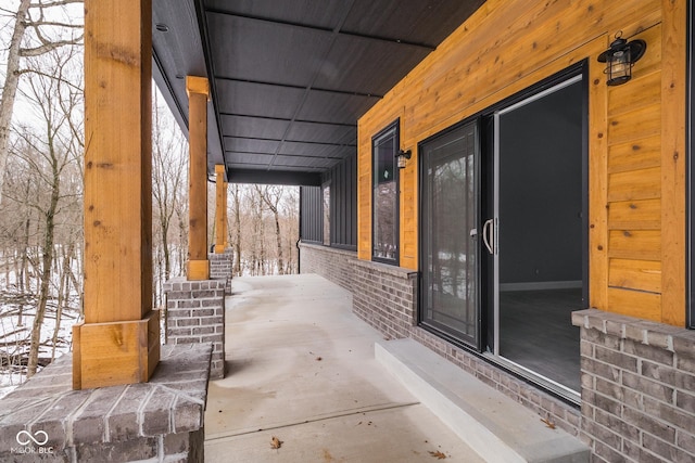 snow covered patio featuring a porch