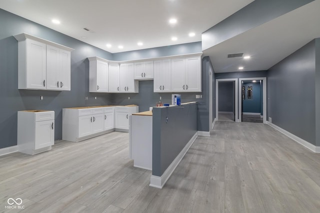 kitchen with white cabinetry and light hardwood / wood-style flooring