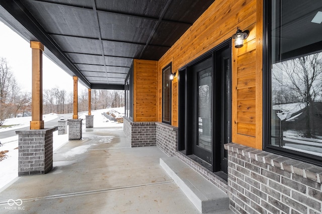 snow covered patio with a porch