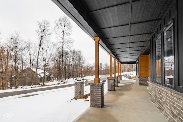 snow covered patio featuring covered porch