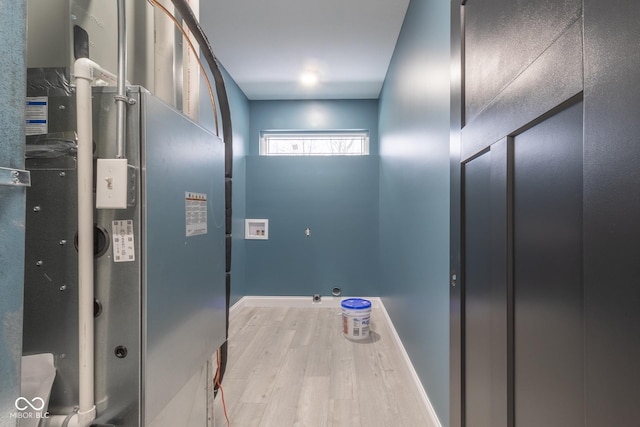 washroom featuring heating unit, washer hookup, and light hardwood / wood-style floors