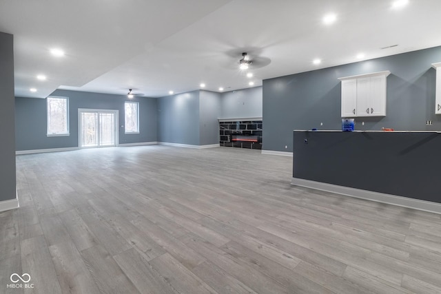 unfurnished living room with ceiling fan and light hardwood / wood-style flooring