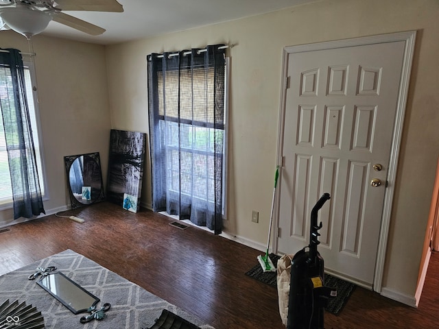 living room featuring ceiling fan and dark wood-type flooring