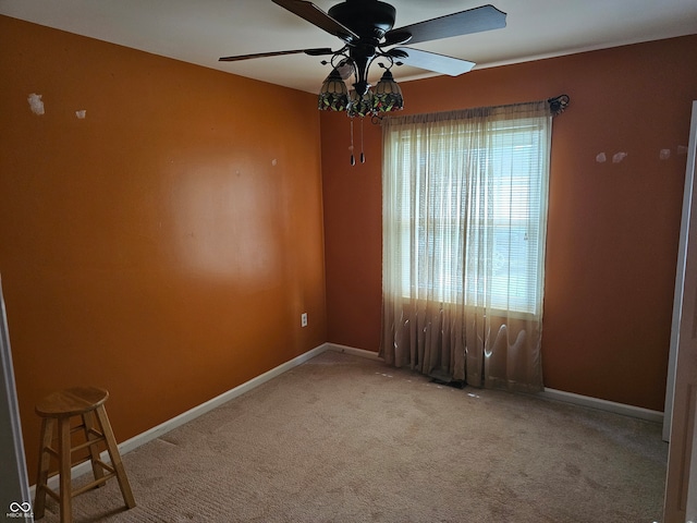 carpeted spare room featuring ceiling fan