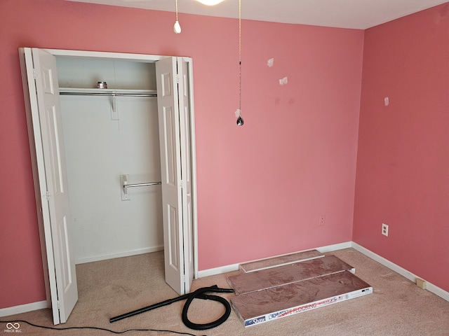 unfurnished bedroom with light colored carpet and a closet