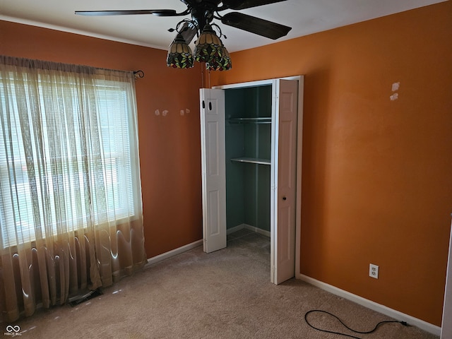 unfurnished bedroom with ceiling fan, a closet, and carpet flooring