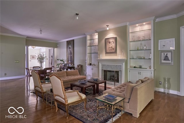 living room with dark hardwood / wood-style flooring, built in shelves, and crown molding