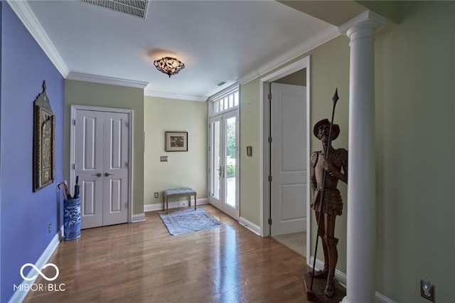 entrance foyer featuring ornamental molding, decorative columns, and light hardwood / wood-style flooring