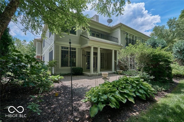 rear view of house with a patio and a balcony