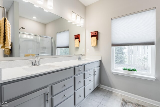 bathroom featuring vanity, a shower with shower door, and tile patterned flooring