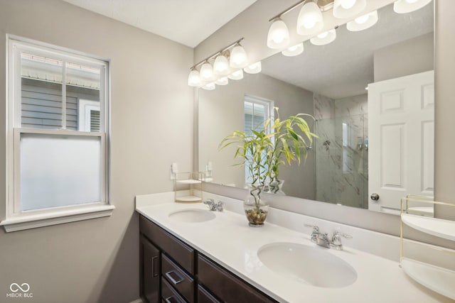 bathroom featuring a shower with shower door and vanity