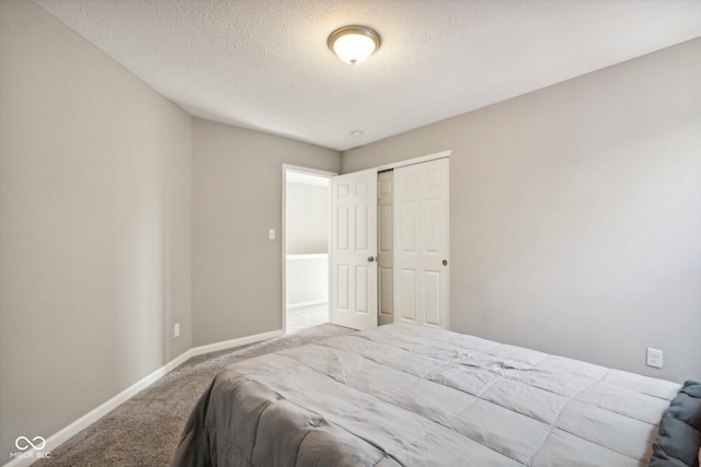 carpeted bedroom featuring a closet and a textured ceiling