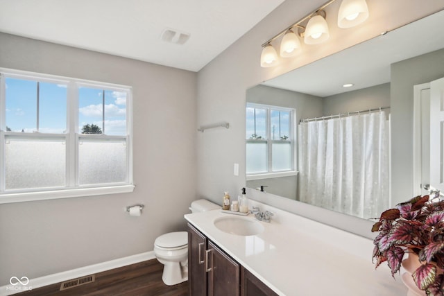 bathroom featuring toilet, vanity, and hardwood / wood-style floors