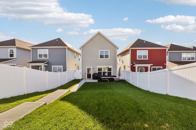 rear view of property featuring a lawn