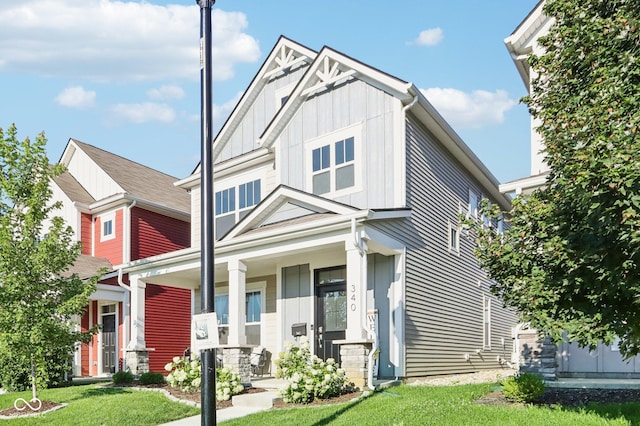 craftsman-style house featuring covered porch and a front lawn