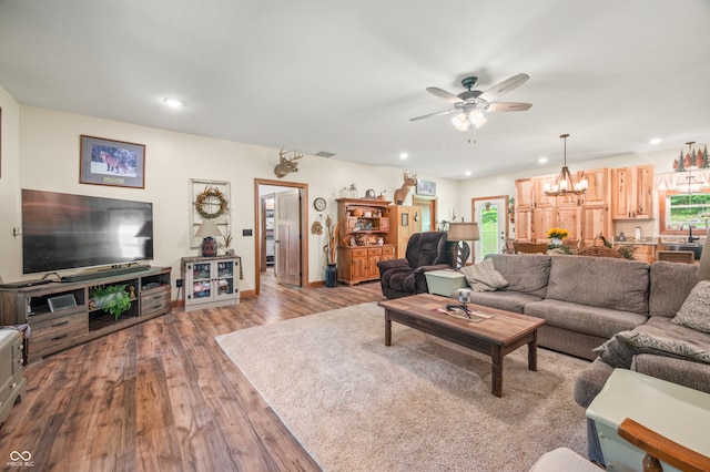 living room with sink, ceiling fan with notable chandelier, and wood-type flooring