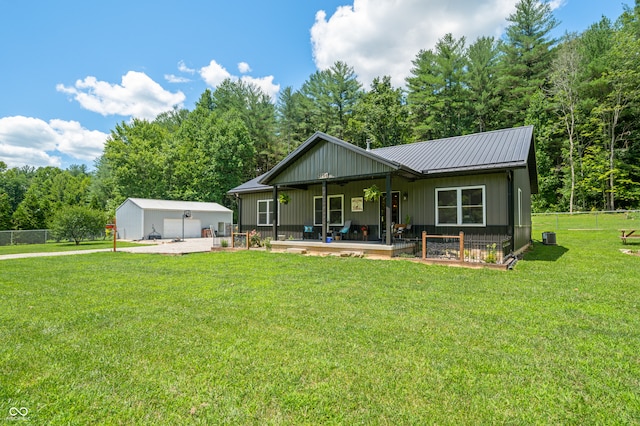 back of house with a garage, a yard, and an outbuilding